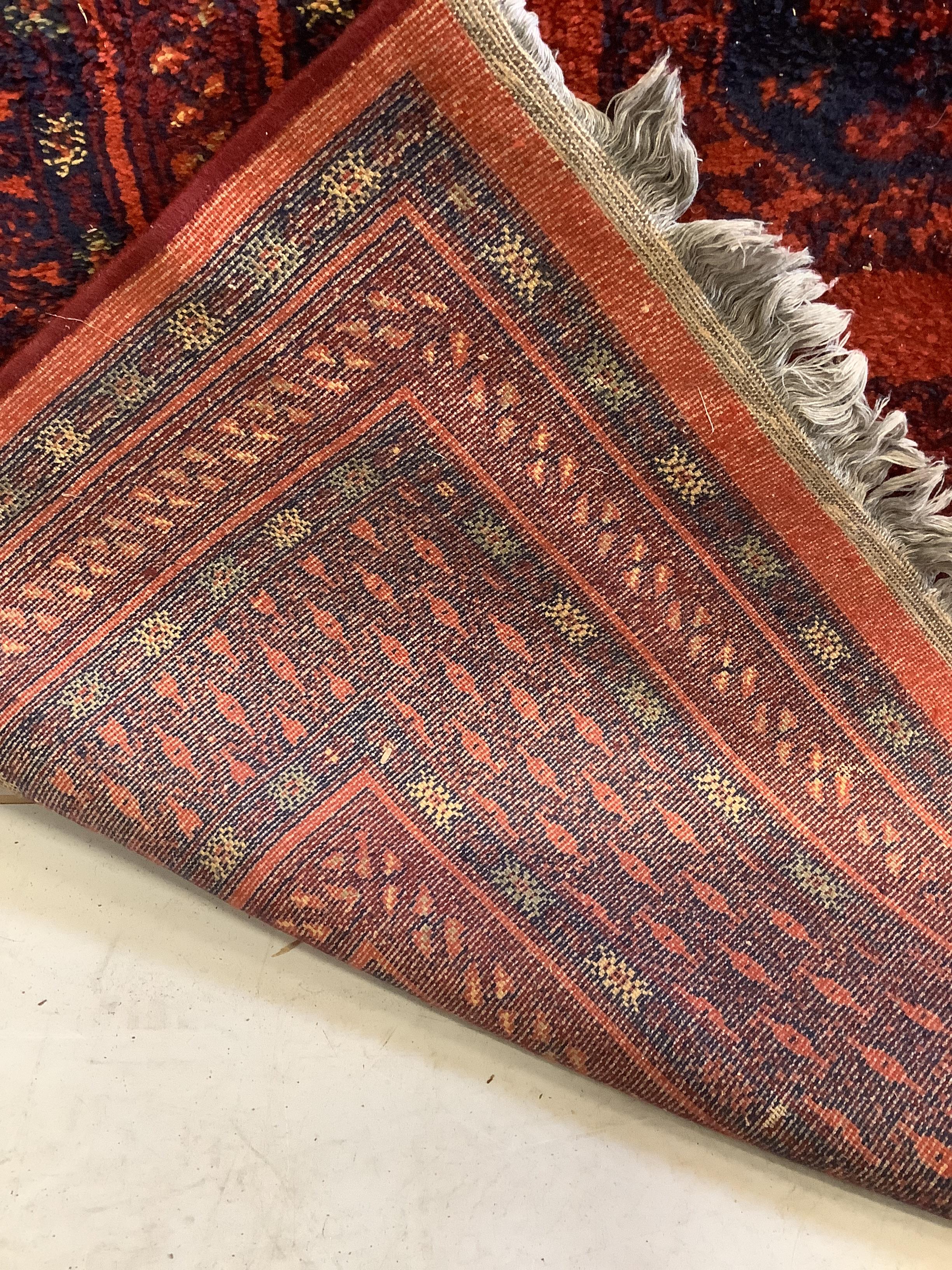 An Afghan style red ground carpet, 280 x 191cm